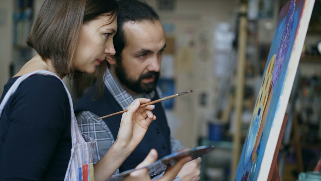 Two colleagues discussing a project in front of a whiteboard with diagrams